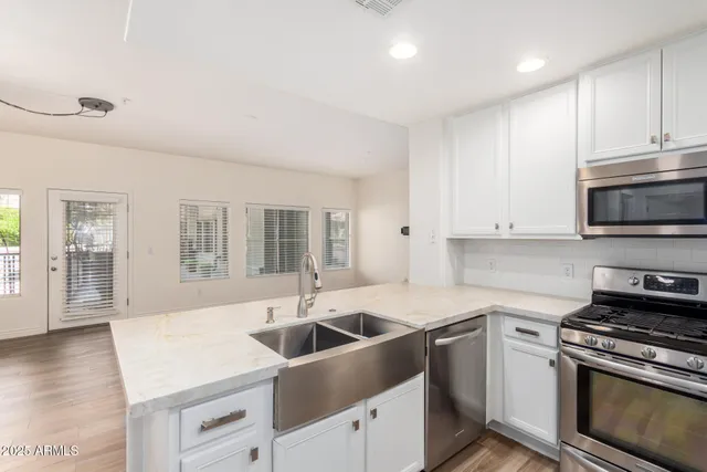 a kitchen with stainless steel appliances granite countertop a sink and a stove
