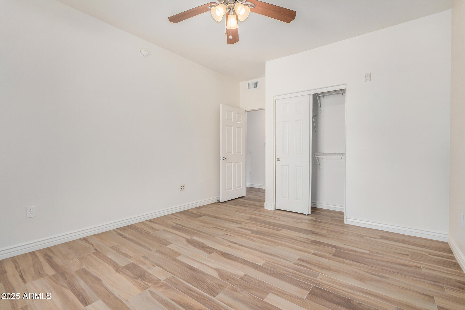 5450 East Deer Valley Drive, Unit 1211 Phoenix, AZ 85054 - Photo 13 of 26 a view of an empty room with wooden floor