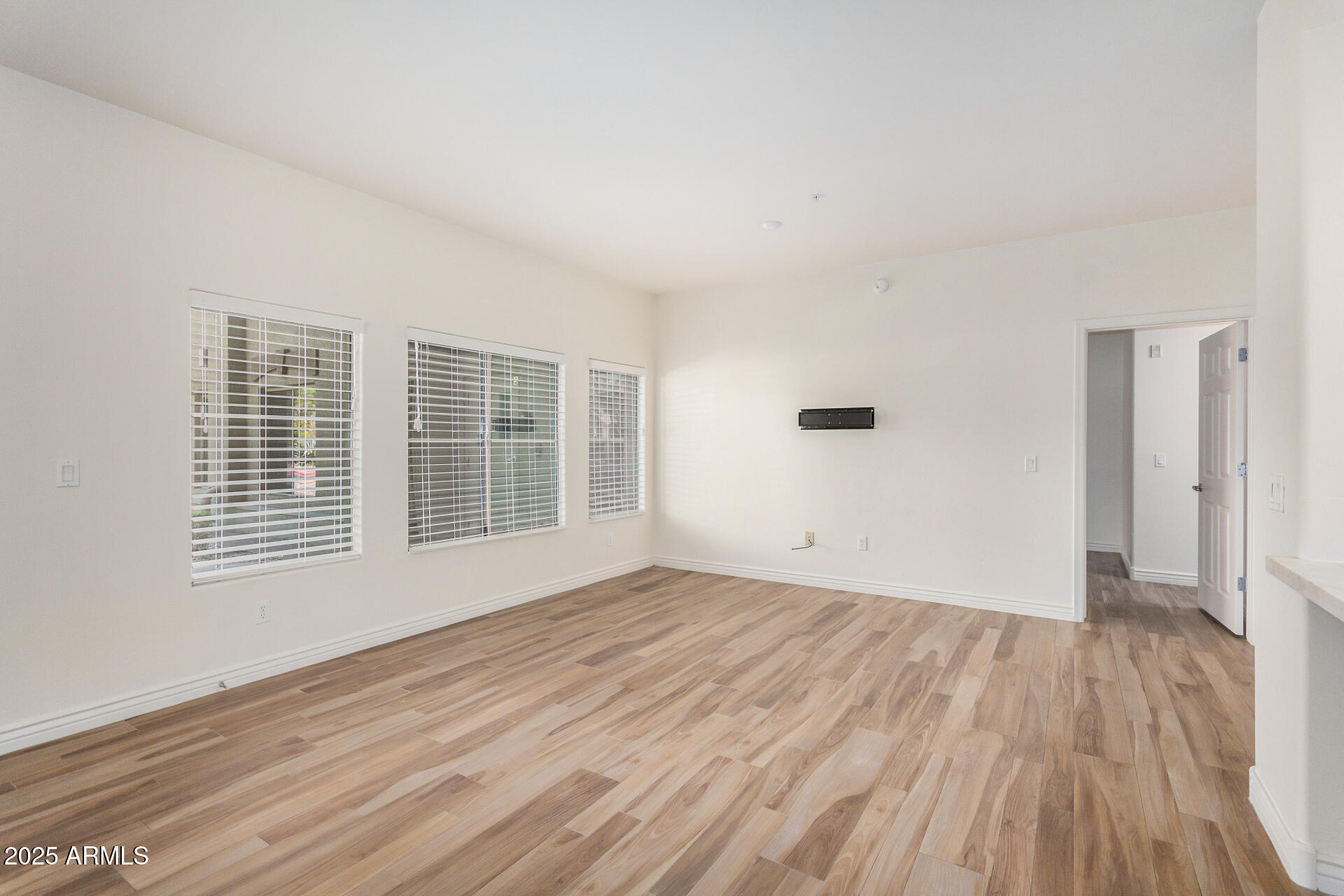 5450 East Deer Valley Drive, Unit 1211 Phoenix, AZ 85054 - Photo 22 of 26 a view of an empty room with wooden floor and a window