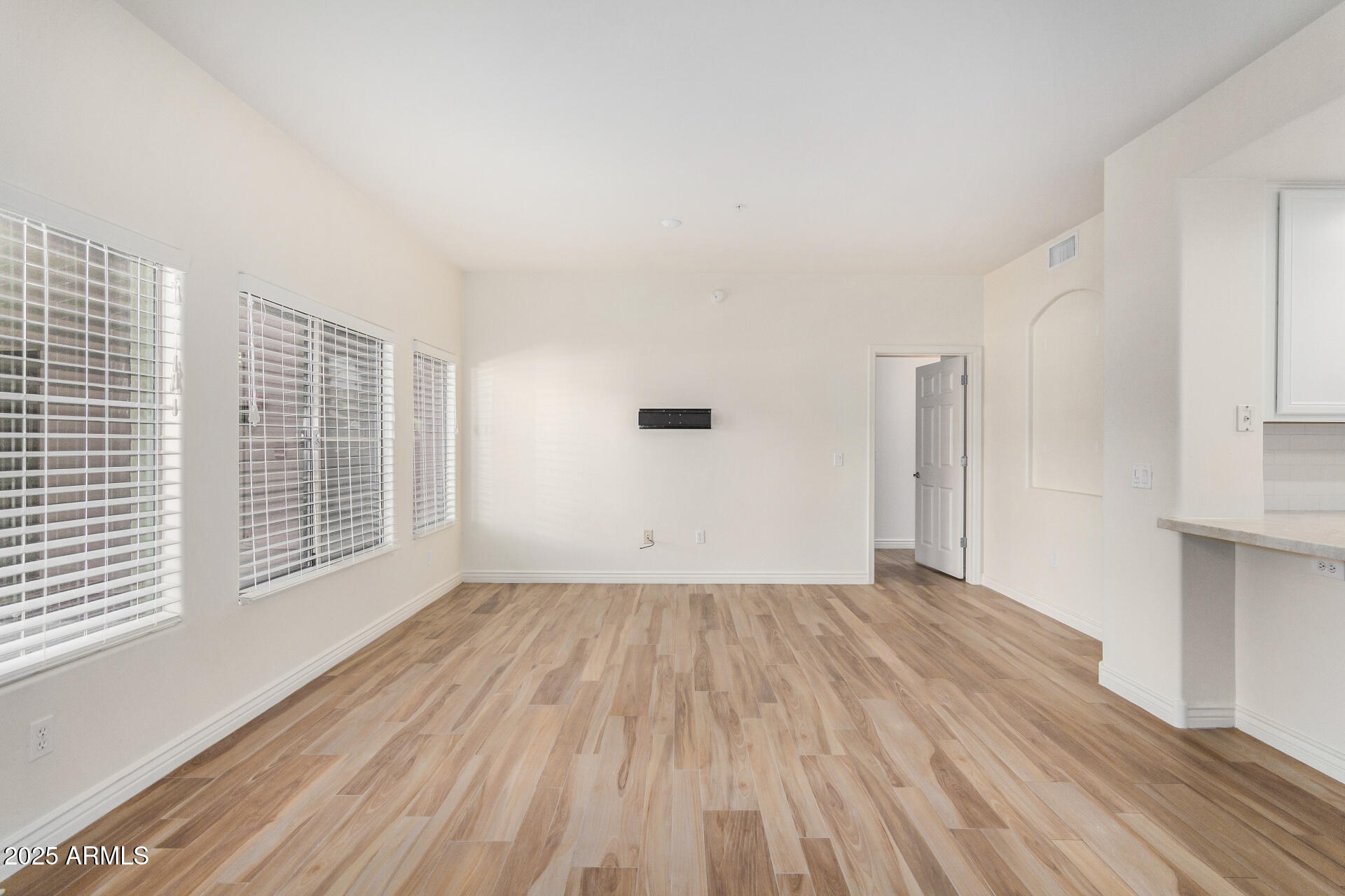 5450 East Deer Valley Drive, Unit 1211 Phoenix, AZ 85054 - Photo 26 of 26 a view of an empty room with wooden floor and a window