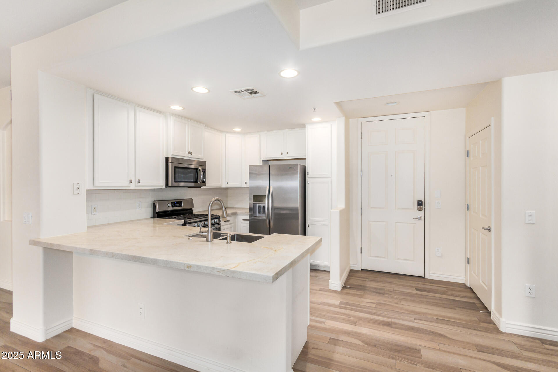 5450 East Deer Valley Drive, Unit 1211 Phoenix, AZ 85054 - Photo 4 of 26 a kitchen with stainless steel appliances a refrigerator sink and microwave