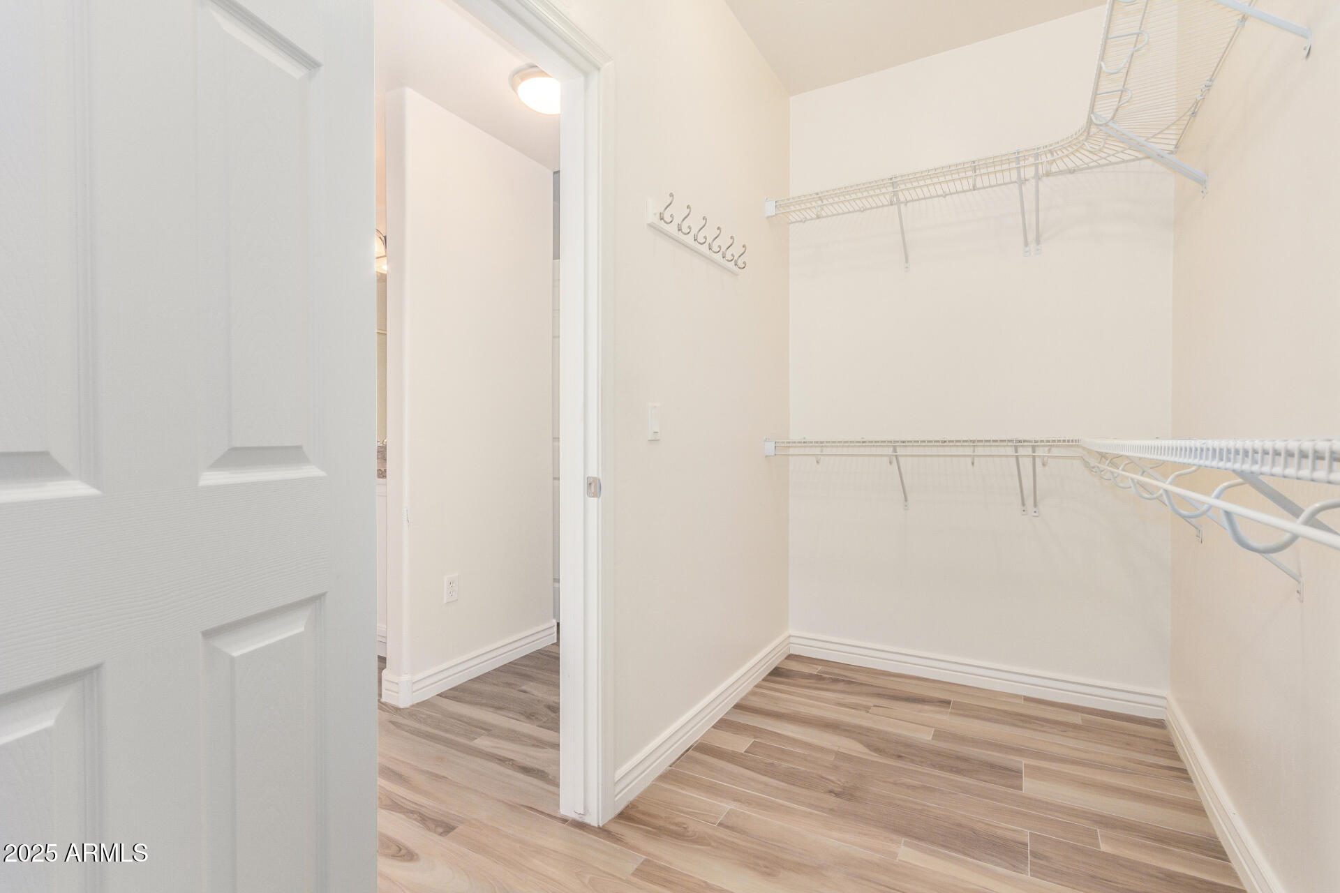 5450 East Deer Valley Drive, Unit 1211 Phoenix, AZ 85054 - Photo 9 of 26 a view of an empty walk in closet with wooden floor