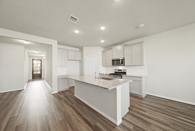 10422 Sherwin Pass Drive Rosharon, TX 77583 - Photo 8 of 26 a kitchen with cabinets wooden floor and stainless steel appliances