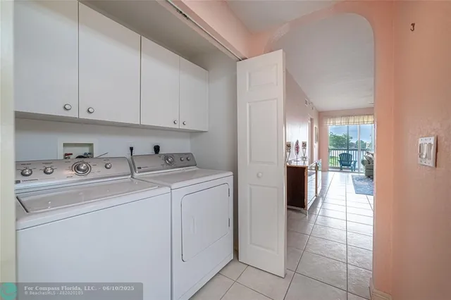a view of washer and dryer with kitchen in the background