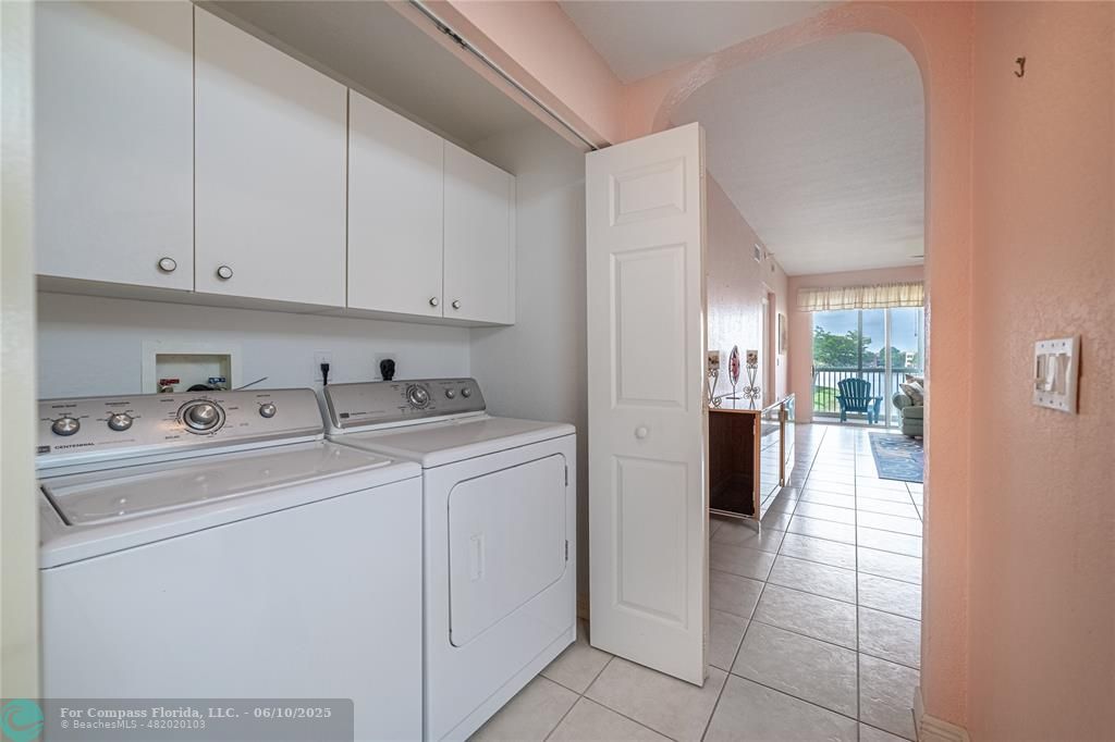 7739 Southampton Terrace, Unit 202 Tamarac, FL 33321 - Photo 12 of 39 a view of washer and dryer with kitchen in the background