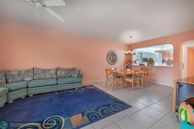 a living room with furniture and a dining table with garden view