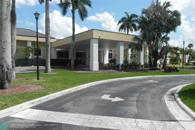 a view of a house with a yard and palm trees