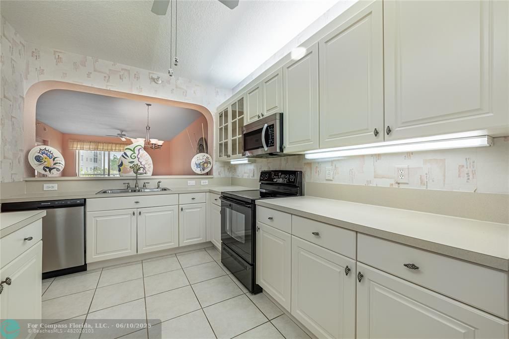 7739 Southampton Terrace, Unit 202 Tamarac, FL 33321 - Photo 6 of 39 a kitchen with cabinets appliances a sink and a counter top space