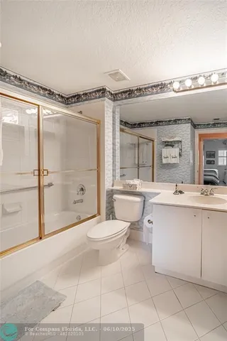 a spacious bathroom with a granite countertop sink toilet a mirror and shower