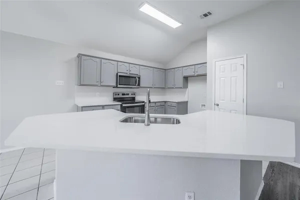 a white kitchen with cabinets and a stainless steel appliances