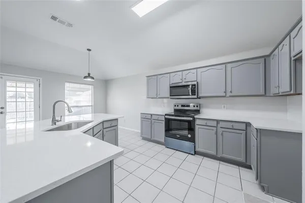 a kitchen with stainless steel appliances granite countertop a sink dishwasher stove top oven and cabinets