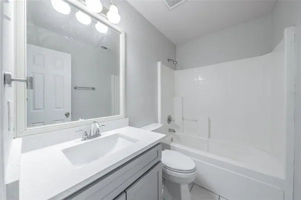 a bathroom with a sink a toilet a mirror and shower