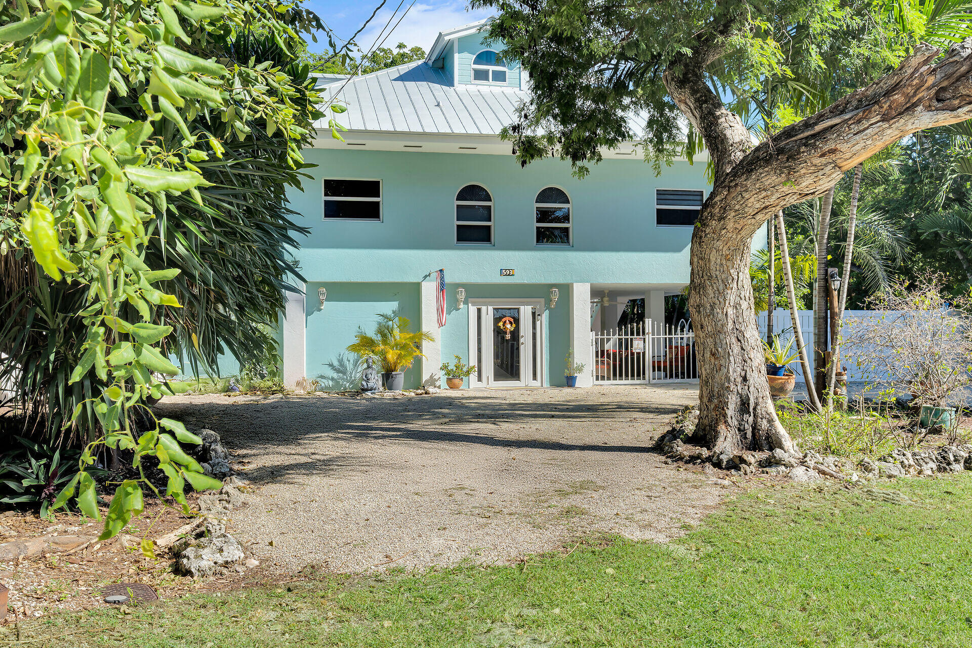 593 Bonito Avenue Key Largo, FL 33037 - Photo 48 of 72 a view of a white house next to a yard with large trees