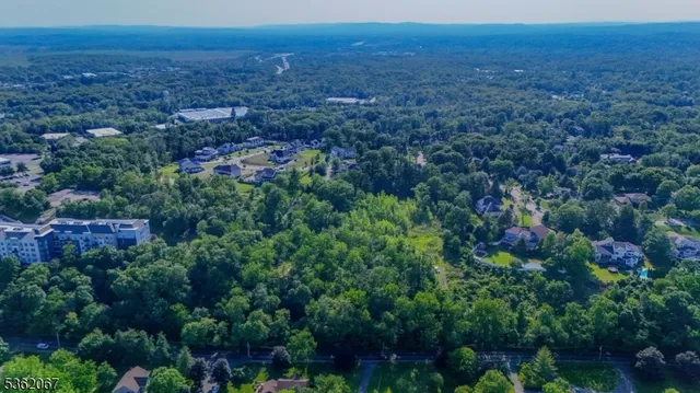 an aerial view of residential house with outdoor space and trees all around