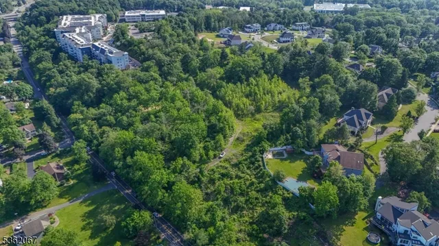 an aerial view of residential house with outdoor space and trees all around