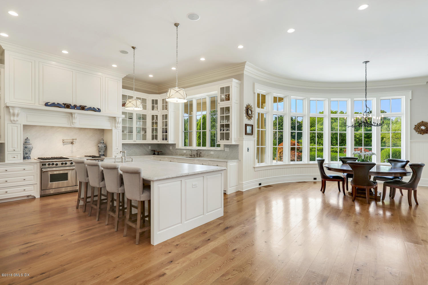 35 Close Road Greenwich, CT 06831 - Photo 15 of 78 a open kitchen with stainless steel appliances granite countertop a stove top oven a dining table and chairs with wooden floor
