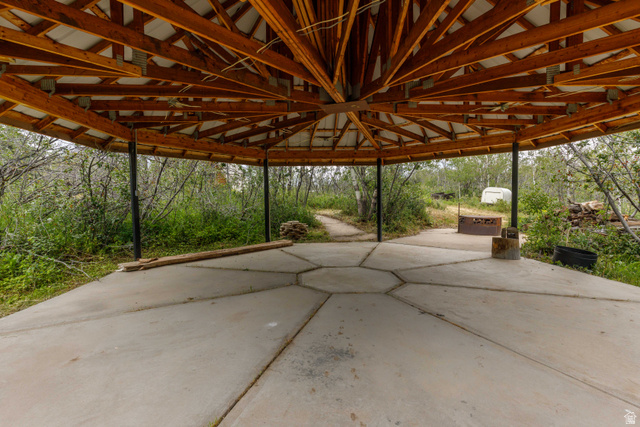 23 Scare Canyon, Unit 23 Logan, UT 84321 - Photo 21 of 33 Expansive concrete patio area with a hexagonal pattern, covered by a wooden beam ceiling structure