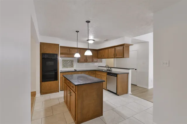 a kitchen with stainless steel appliances granite countertop a sink and a refrigerator