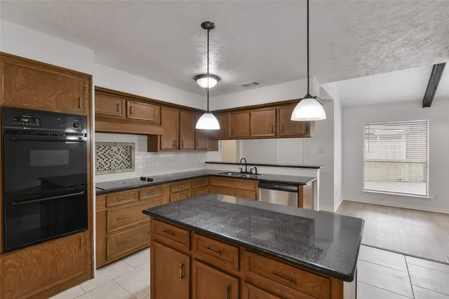 a kitchen with a refrigerator a sink and wooden floor