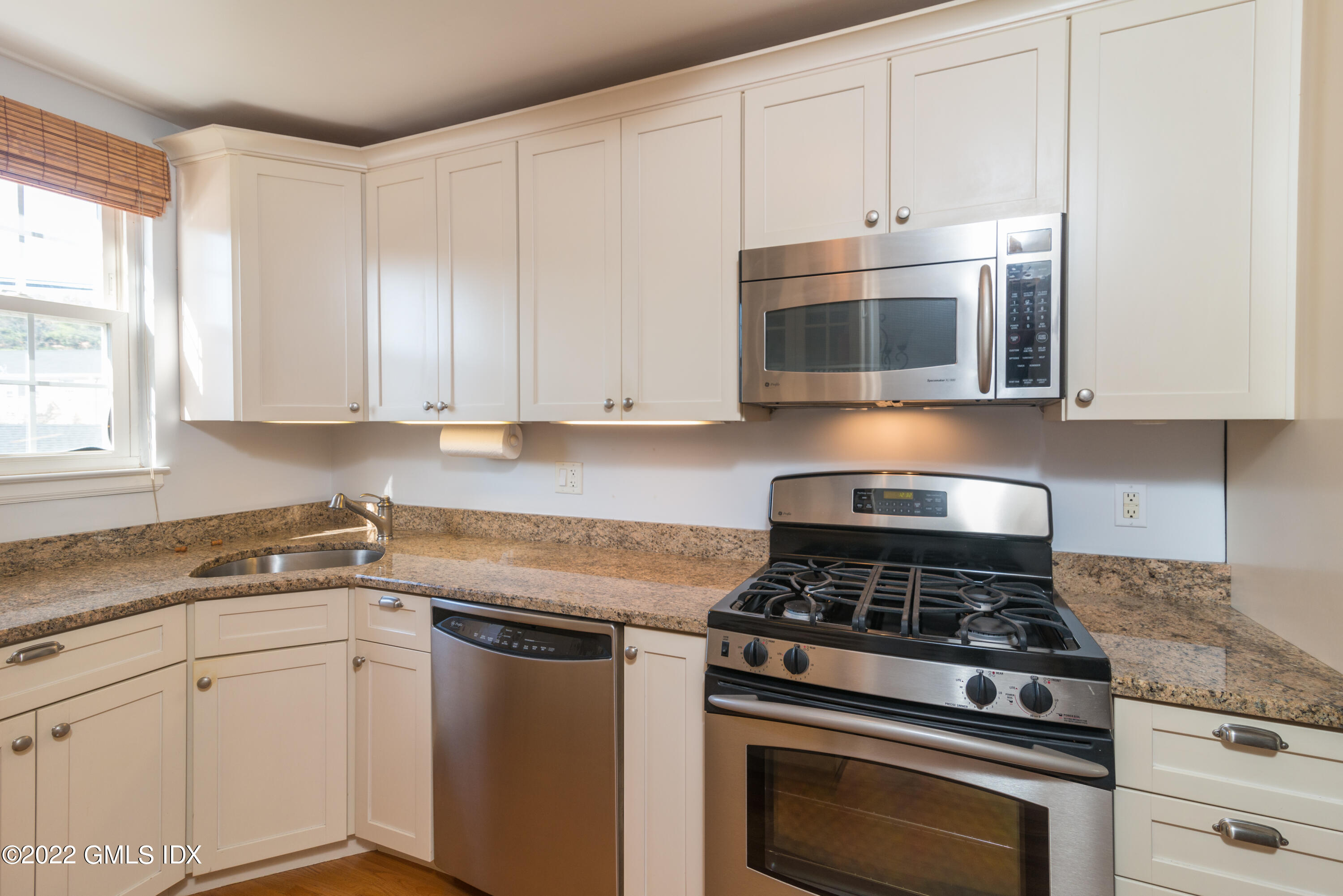 70 Putnam Park, Unit 70 Greenwich, CT 06830 - Photo 5 of 20 a kitchen with cabinets stainless steel appliances and a window