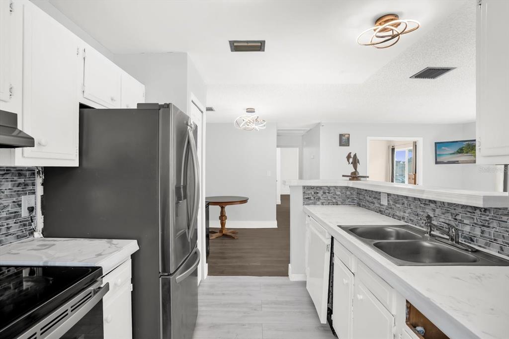 1121 Spring Meadow Drive, Unit 11221 Kissimmee, FL 34741 - Photo 12 of 28 a kitchen with stainless steel appliances granite countertop a sink stove and refrigerator