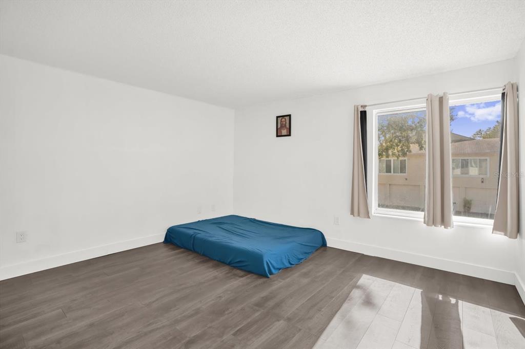 1121 Spring Meadow Drive, Unit 11221 Kissimmee, FL 34741 - Photo 15 of 28 a view of an empty room with wooden floor and a window