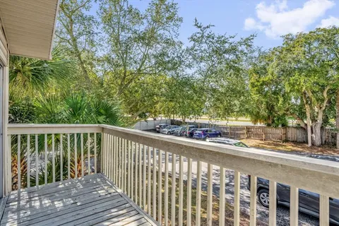 a balcony with wooden floor and yard in the back