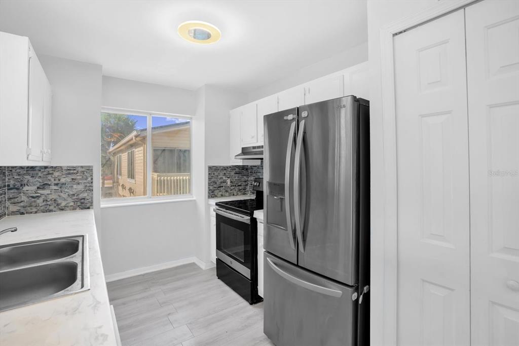 1121 Spring Meadow Drive, Unit 11221 Kissimmee, FL 34741 - Photo 10 of 28 a kitchen with stainless steel appliances granite countertop a refrigerator and a stove