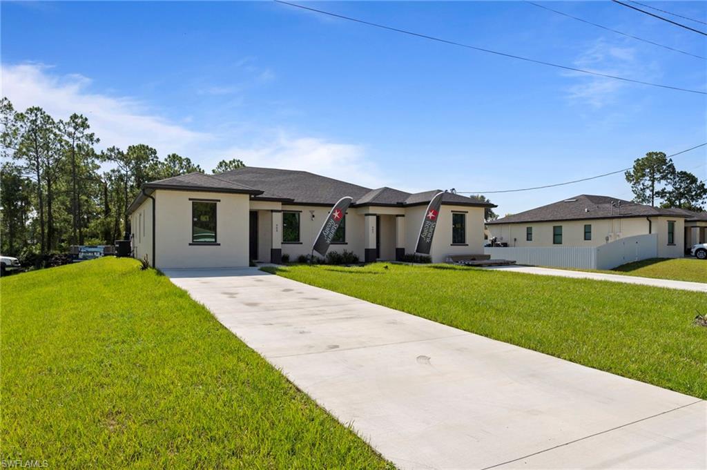 907 Homestead Road South Lehigh Acres, FL 33974 - Photo 27 of 29 a front view of house with yard and green space