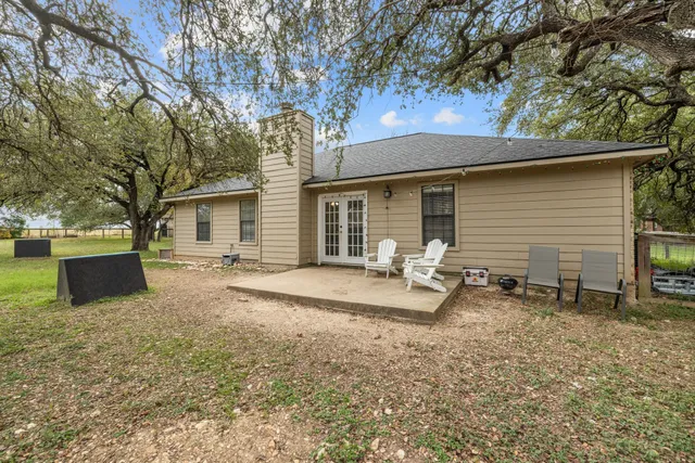 a backyard of a house with table and chairs