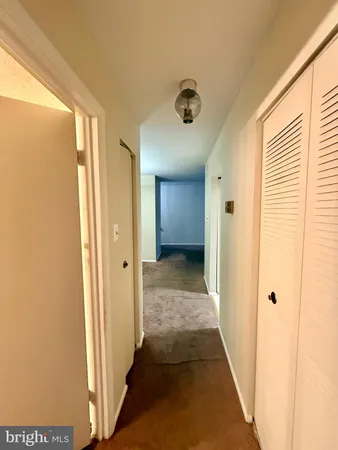 a view of a hallway with a room and a bathroom