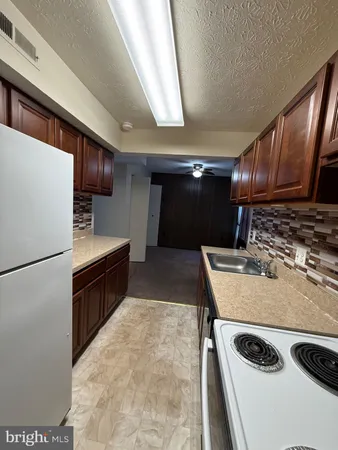 a kitchen with refrigerator and chairs
