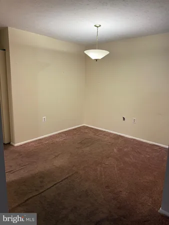 a view of an empty room with a chandelier fan