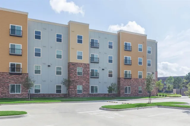 a view of a brick building next to a yard