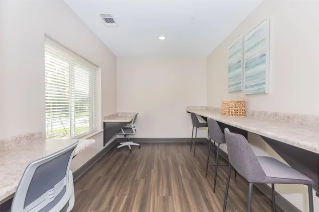a view of a workspace with furniture and a window