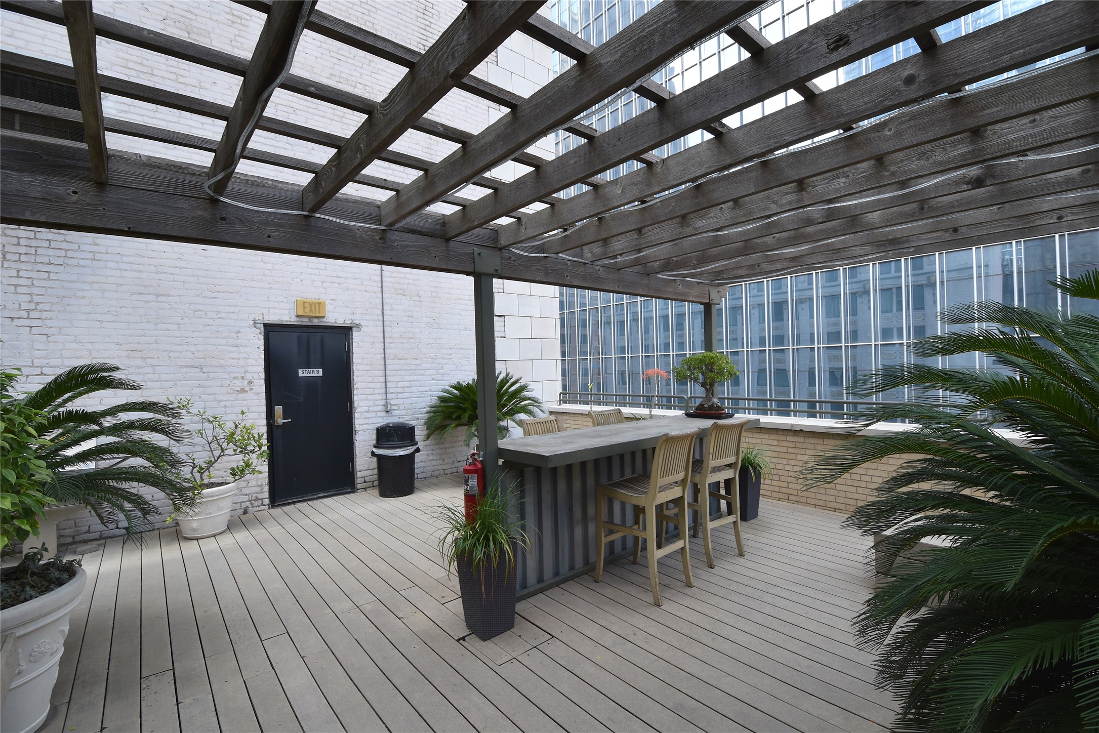705 Main Street, Unit 215 Houston, TX 77002 - Photo 29 of 36 Stylish rooftop patio with a wooden pergola, bar seating.
