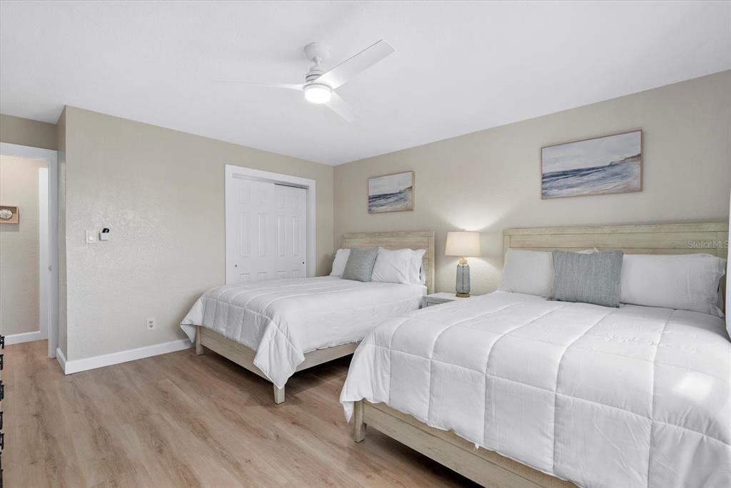 5830 Midnight Pass Road, Unit 25 Sarasota, FL 34242 - Photo 14 of 29 a bedroom with two beds and a ceiling fan