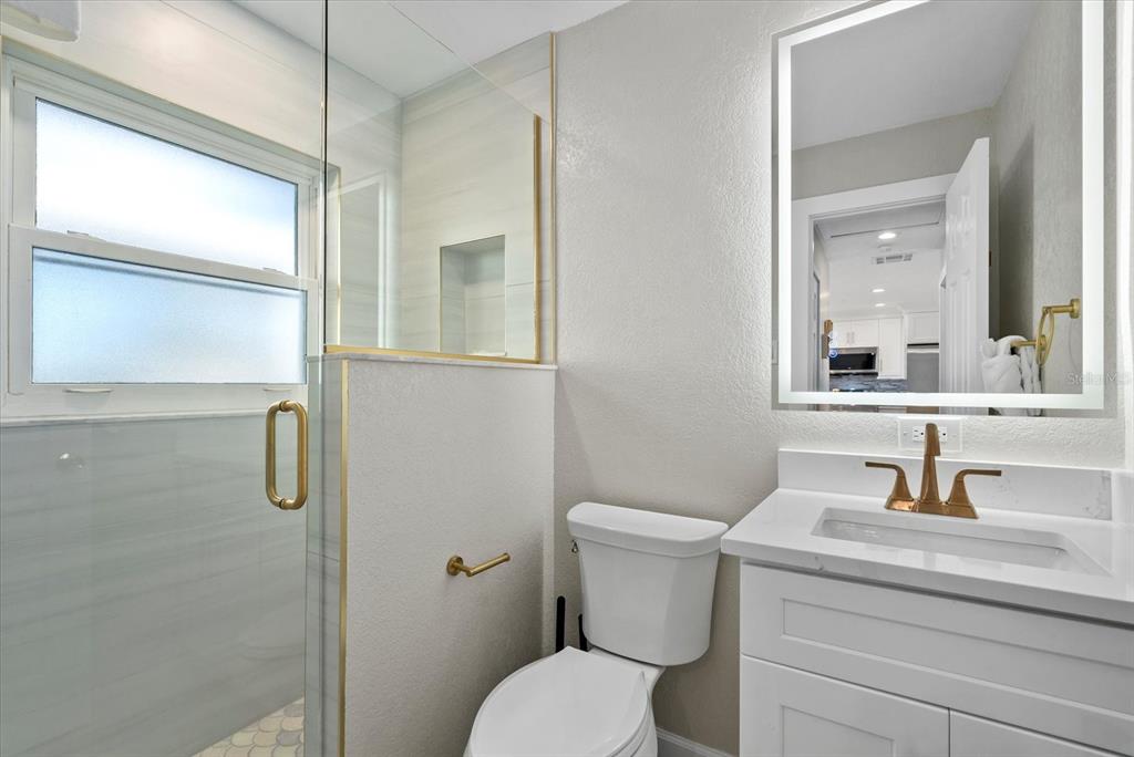 5830 Midnight Pass Road, Unit 25 Sarasota, FL 34242 - Photo 15 of 29 a bathroom with a sink toilet and shower