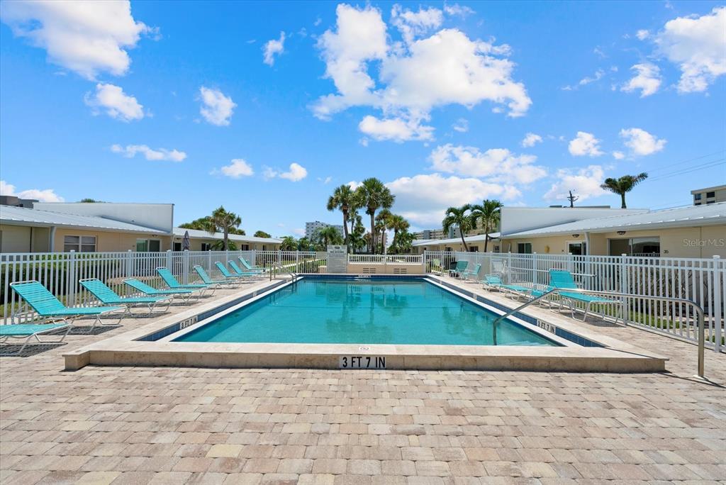 5830 Midnight Pass Road, Unit 25 Sarasota, FL 34242 - Photo 19 of 29 a view of a swimming pool with a lounge chairs