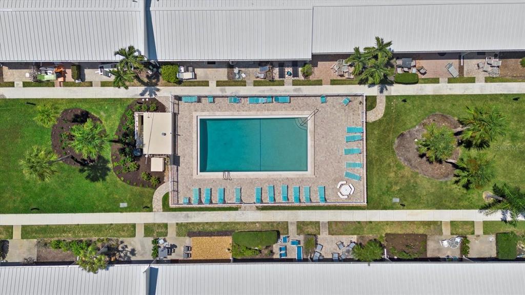 5830 Midnight Pass Road, Unit 25 Sarasota, FL 34242 - Photo 23 of 29 a front view of a house with a garden and swimming pool