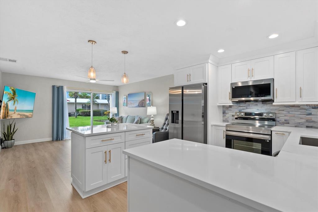 5830 Midnight Pass Road, Unit 25 Sarasota, FL 34242 - Photo 3 of 29 a kitchen with kitchen island a sink stove and refrigerator
