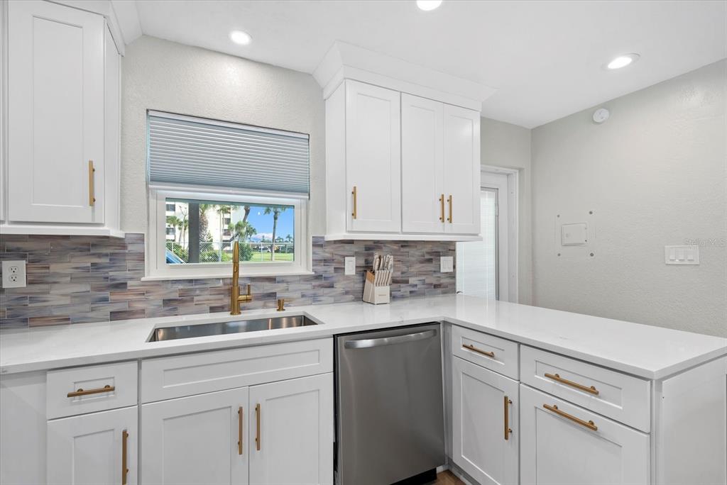 5830 Midnight Pass Road, Unit 25 Sarasota, FL 34242 - Photo 5 of 29 a kitchen with white cabinets and white appliances