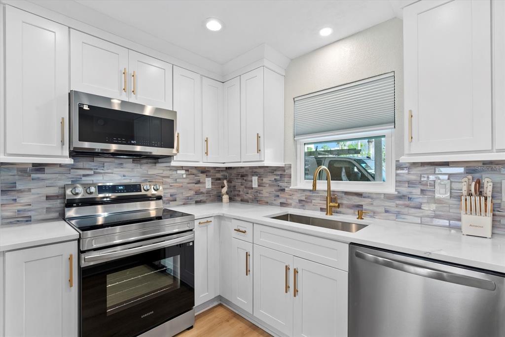 5830 Midnight Pass Road, Unit 25 Sarasota, FL 34242 - Photo 6 of 29 a kitchen with a sink stove and microwave