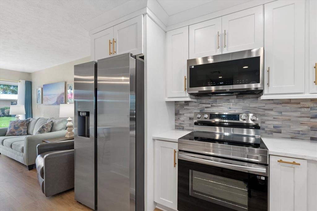 5830 Midnight Pass Road, Unit 25 Sarasota, FL 34242 - Photo 7 of 29 a kitchen with a refrigerator stove and microwave