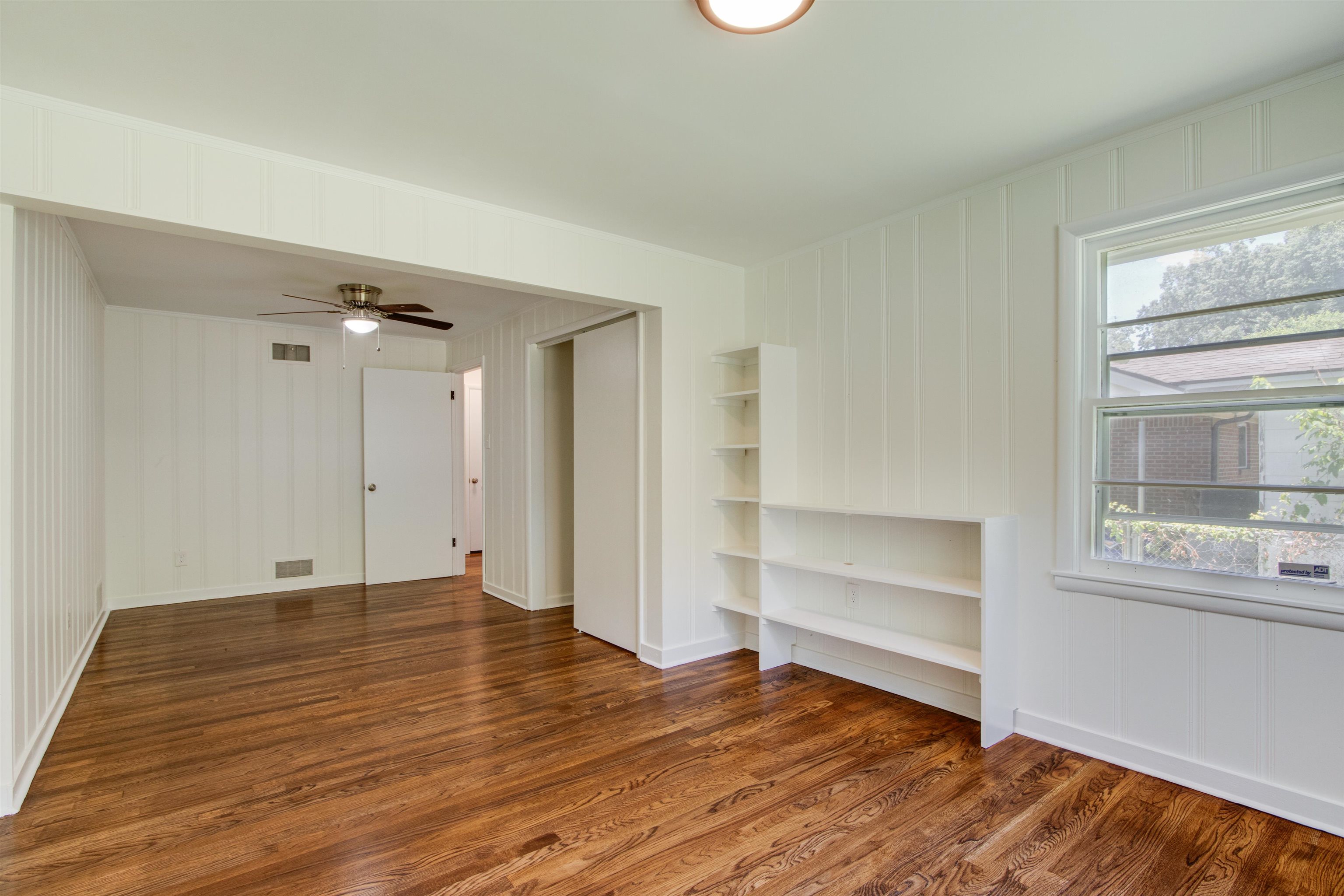 5418 Mesquite Road Memphis, TN 38120 - Photo 18 of 21 Spare room with a healthy amount of sunlight, built in features, ceiling fan, and dark hardwood / wood-style flooring