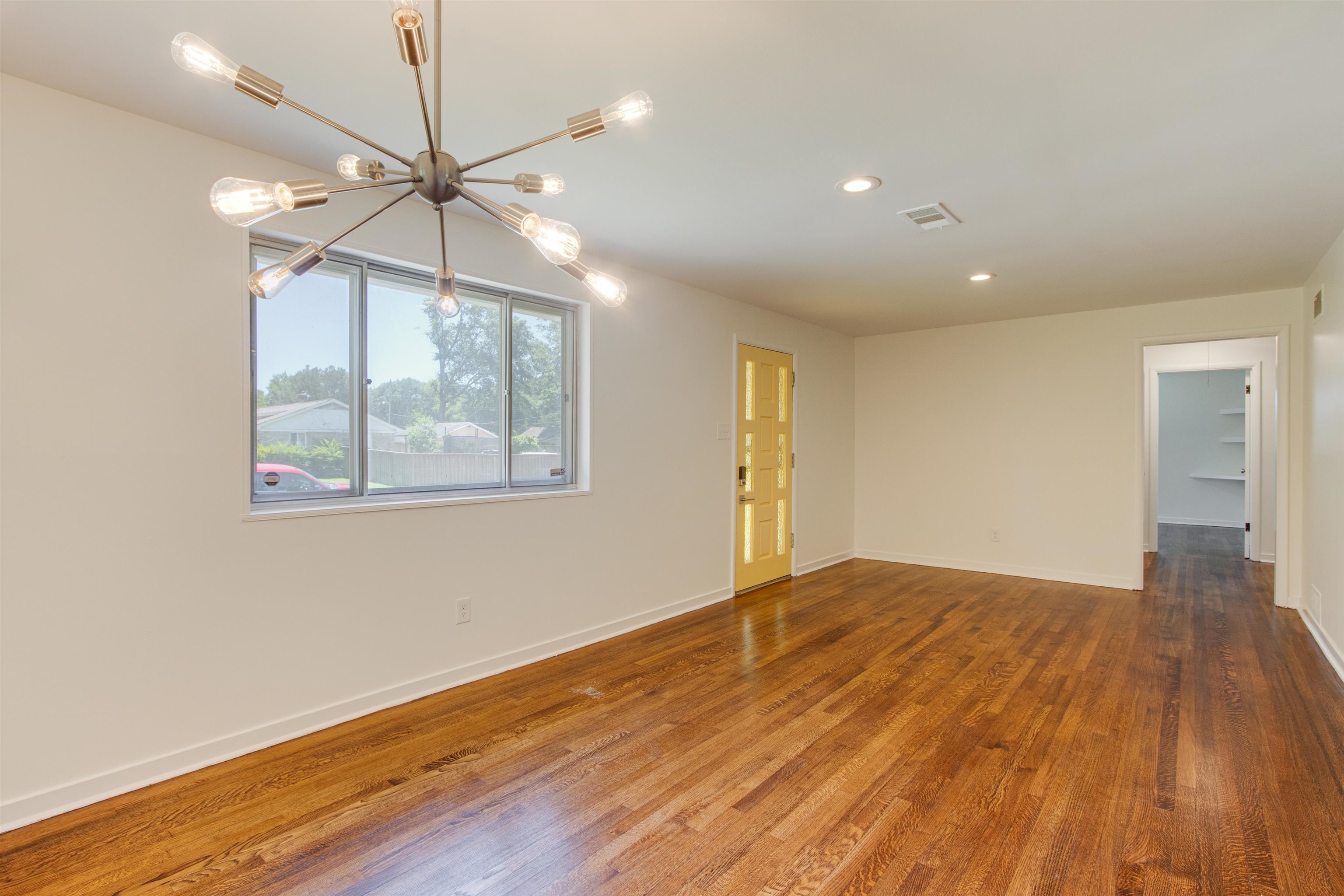 5418 Mesquite Road Memphis, TN 38120 - Photo 5 of 21 Unfurnished room with a chandelier and wood-type flooring