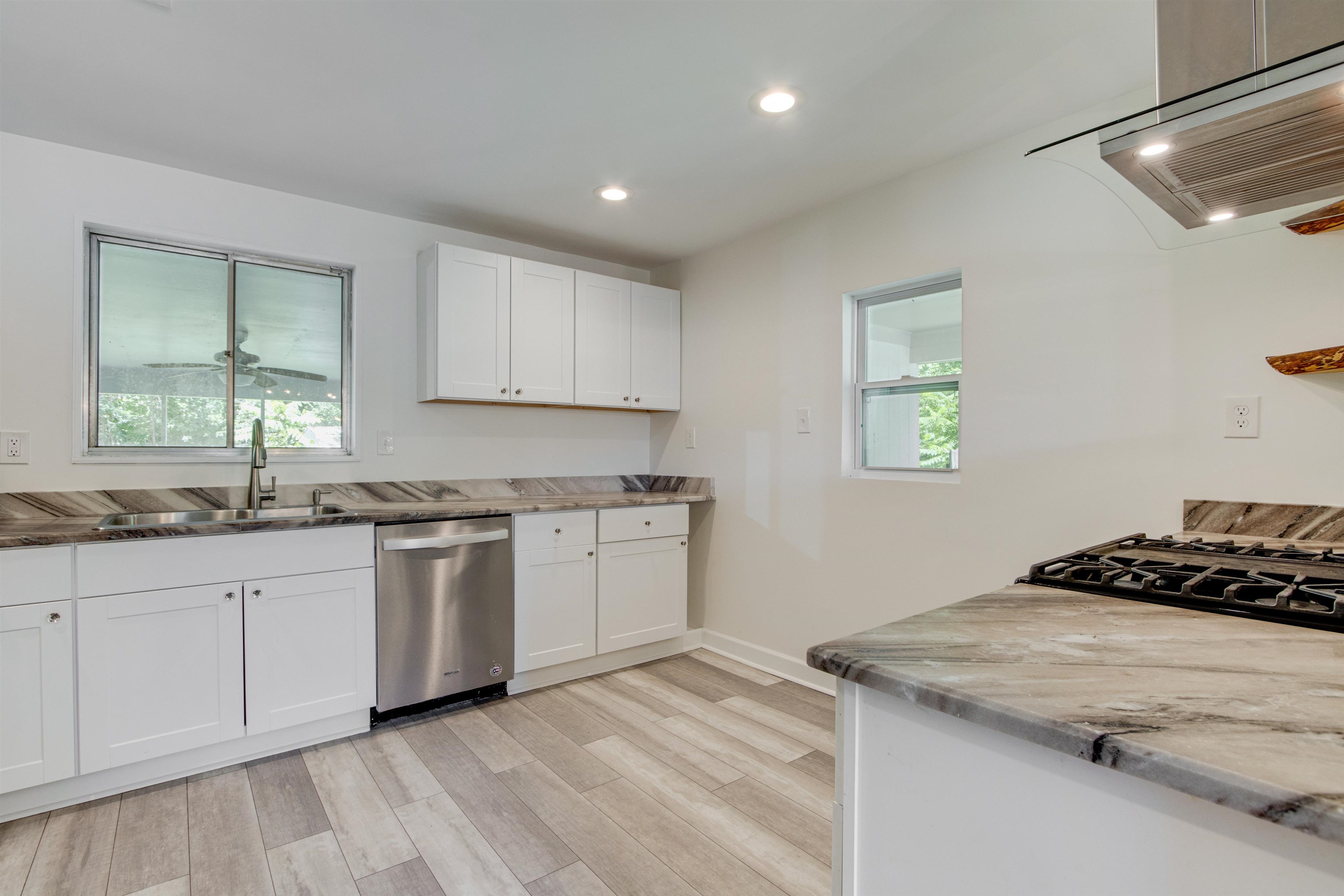 5418 Mesquite Road Memphis, TN 38120 - Photo 9 of 21 Kitchen with extractor fan, white cabinets, a wealth of natural light, and stainless steel dishwasher