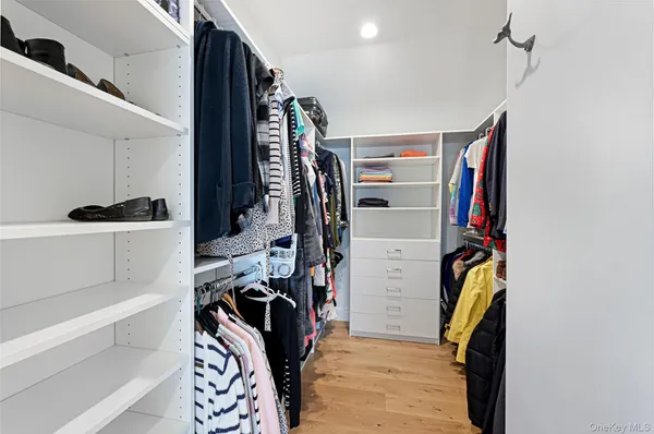a view of walk in closet with clothes and shoes