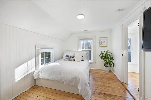 a bedroom with a large bed and wooden floor