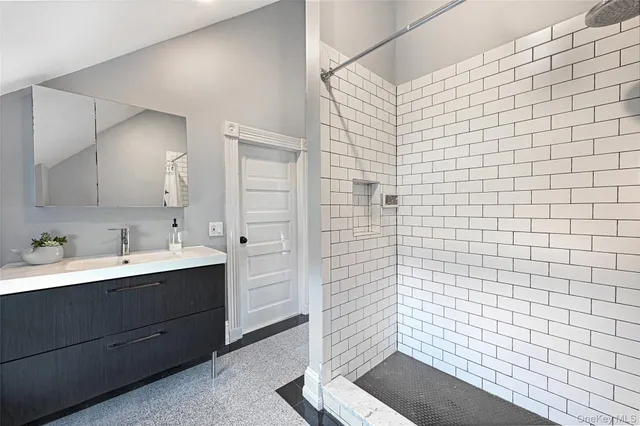 a bathroom with a sink a toilet and shower